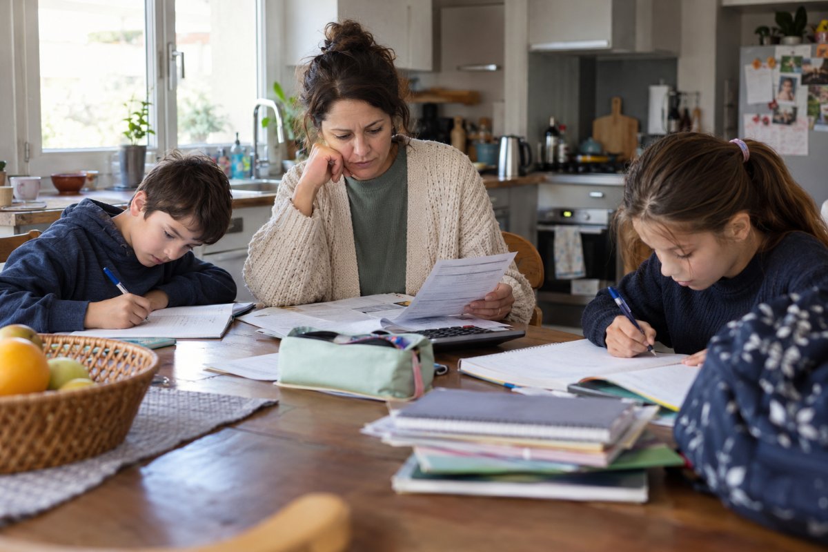 Maman qui fait les comptes de la rentrée scolaire avec ses enfants